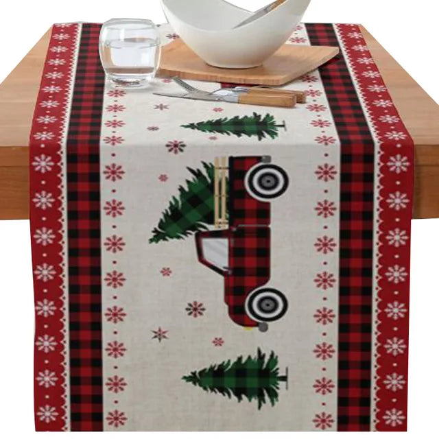 Christmas-themed printed table runner with poinsettia flower, faceless gnome, elk, tree, and snowflake design.